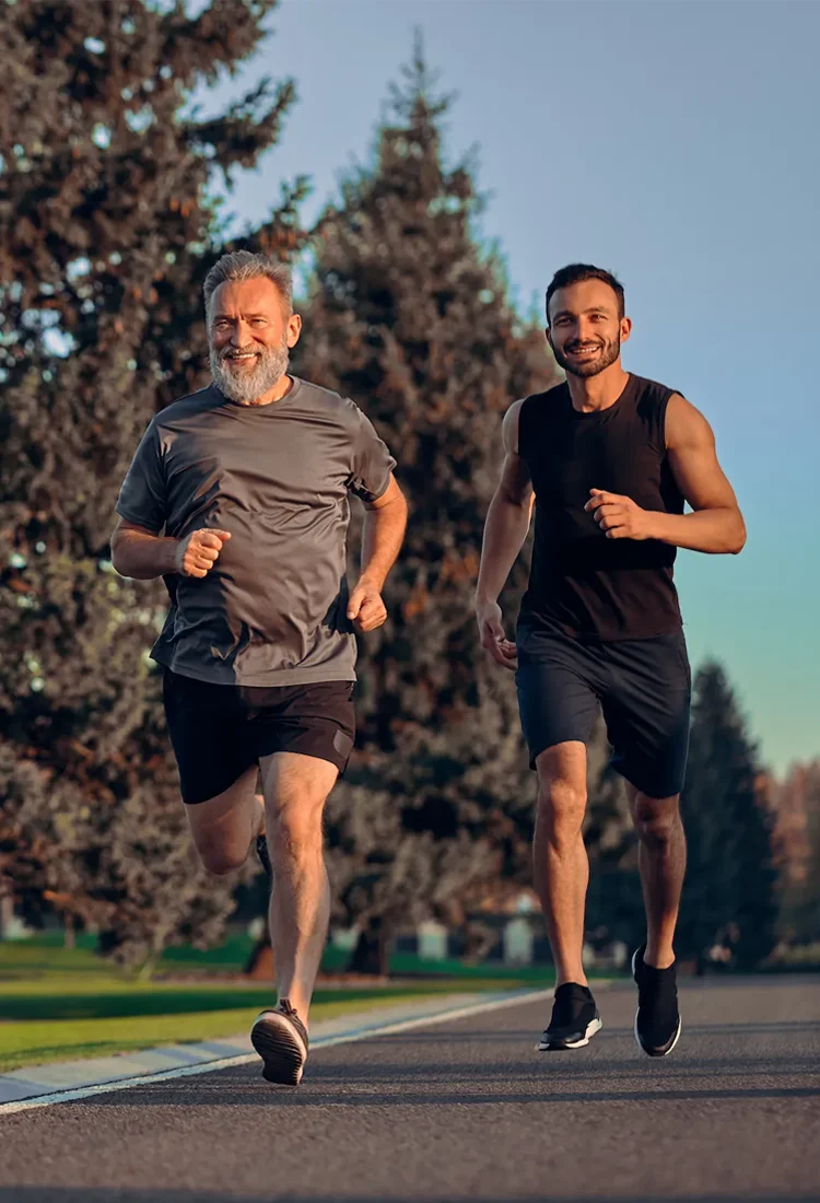 Father and son running together on park road - testosterone replacement therapy clinic in Cottleville MO