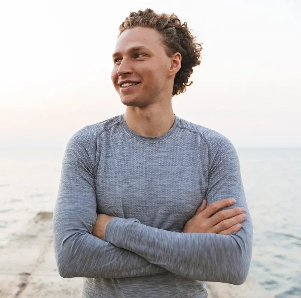 Man in grey athletic sweatshirt smiling - dewrinkle Botox treatment for men