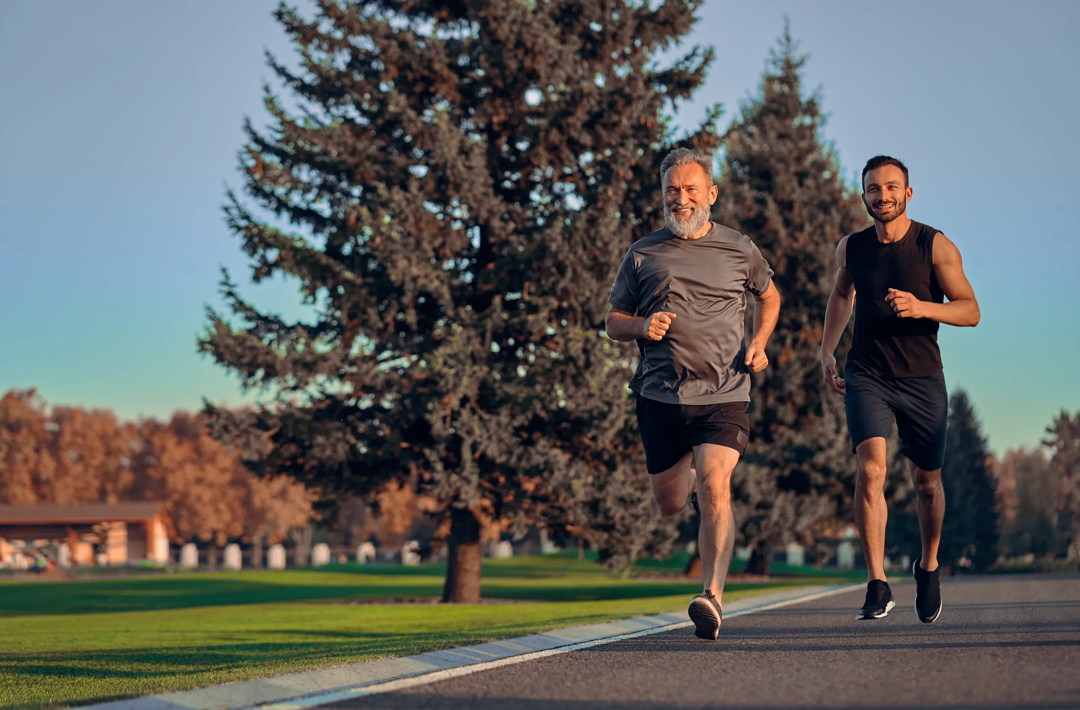 Father and son running together on park road - men's health and TRT services in St. Louis area